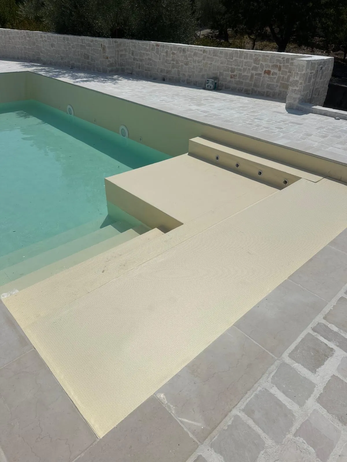 Piscina con scalinata e bordo in pietra