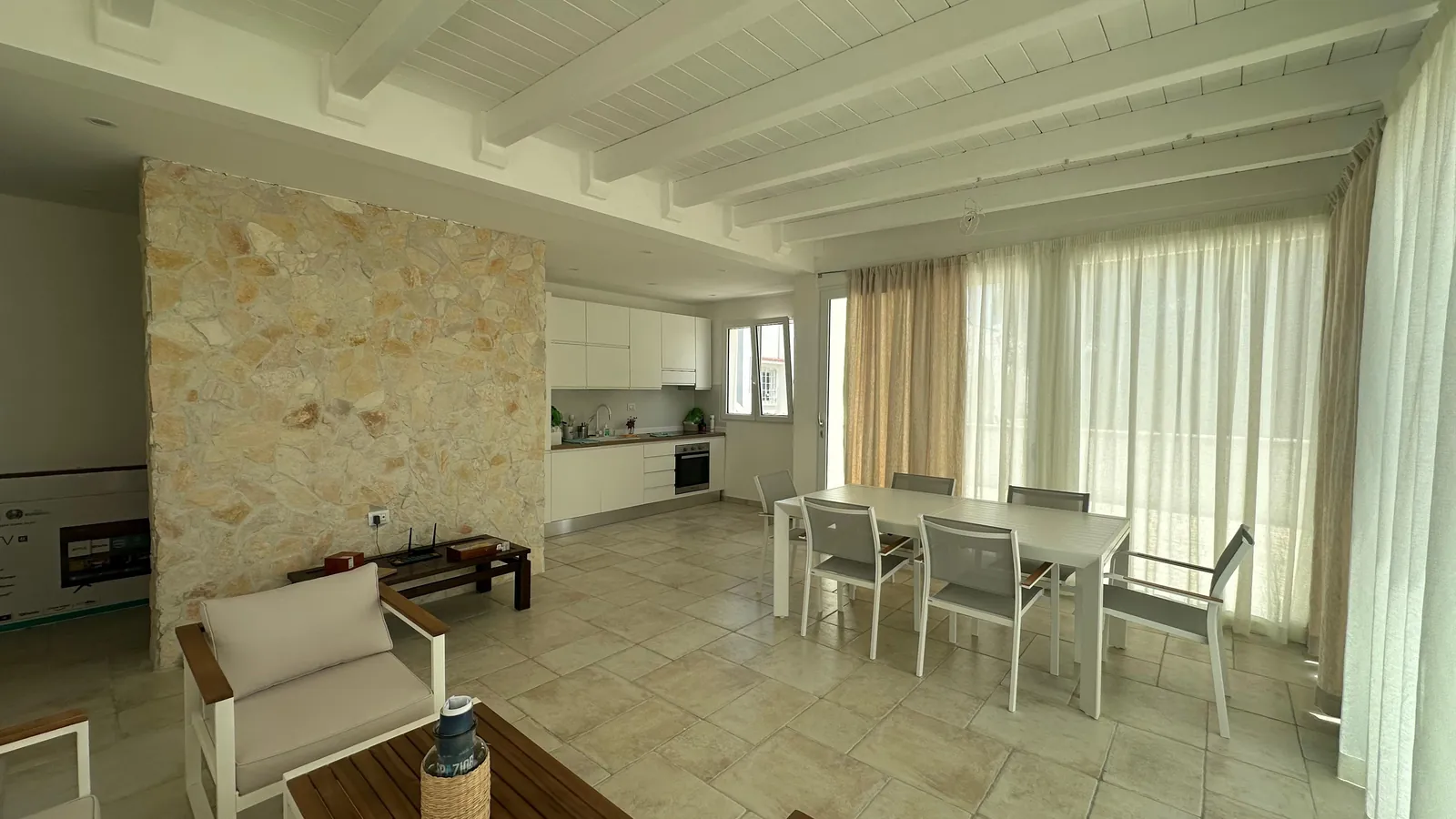 Il soggiorno finito con cucina e parete in pietra